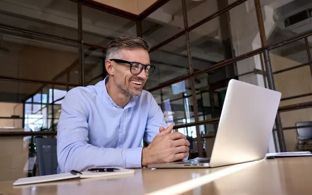 Meneer zit achter laptop te beeldbellen met WeSeeDo in de financiele sector